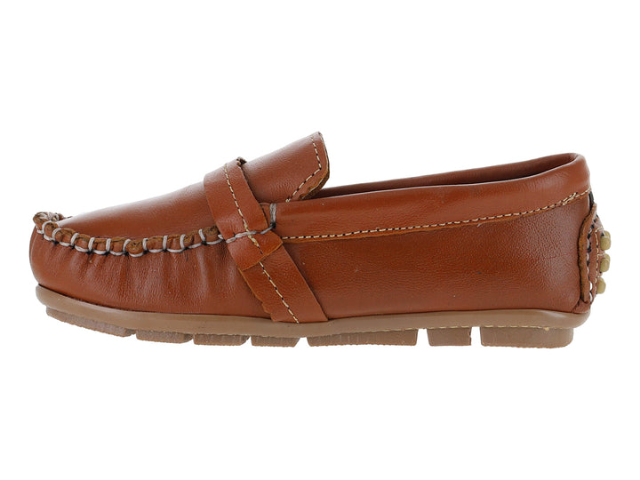 Zapato tipo mocasín para niño en piel color camel con costuras blancas y adorno metálico en el empeine.