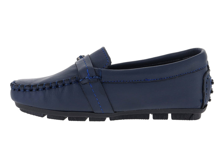 Zapato tipo mocasín para niño en color azul marino con hebilla plateada y suela negra.