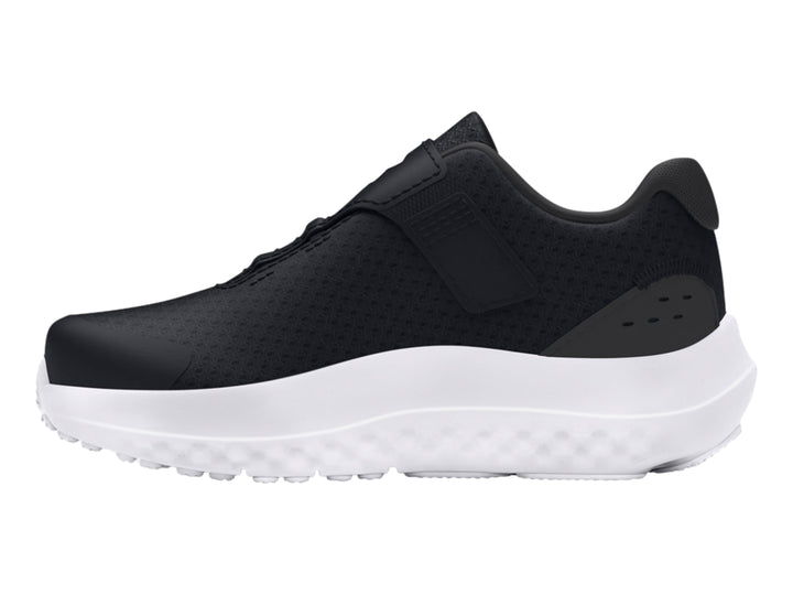 Tenis deportivos Under Armour en color negro con suela blanca y cierre de correa de velcro para niño.