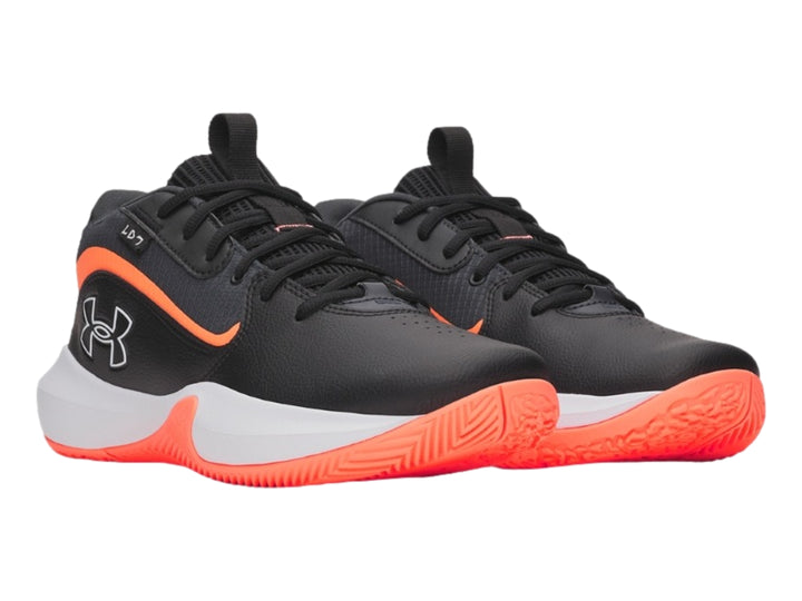 Tenis de baloncesto Under Armour color negro con detalles en naranja y suela blanca.