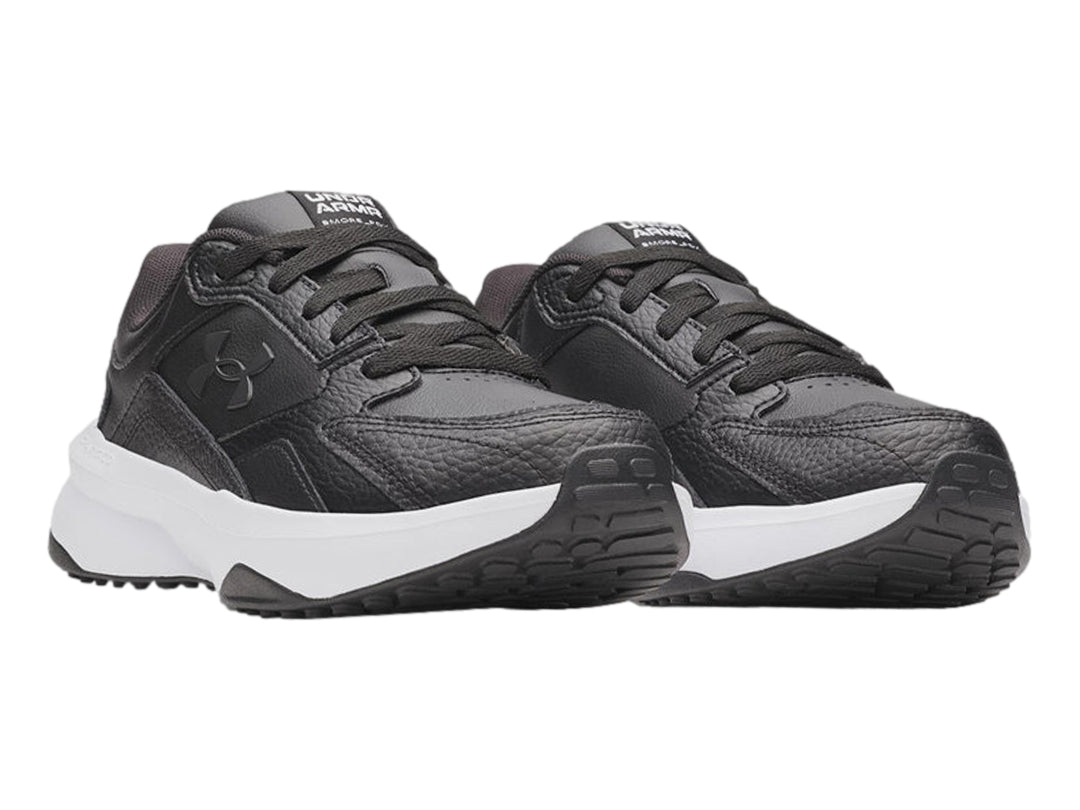 Tenis Under Armour de cuero negro con suela blanca gruesa y cordones negros.