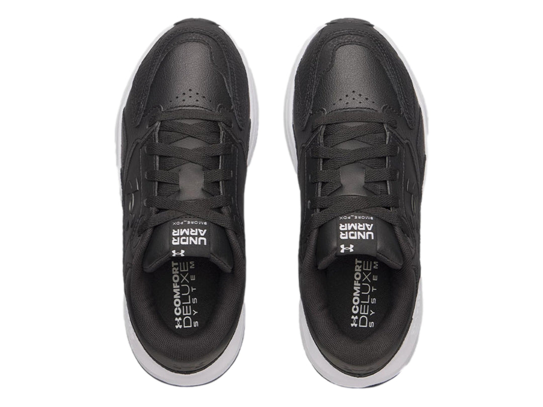 Tenis Under Armour de cuero negro con suela blanca gruesa y cordones negros.