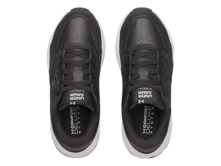 Tenis Under Armour de cuero negro con suela blanca gruesa y cordones negros.