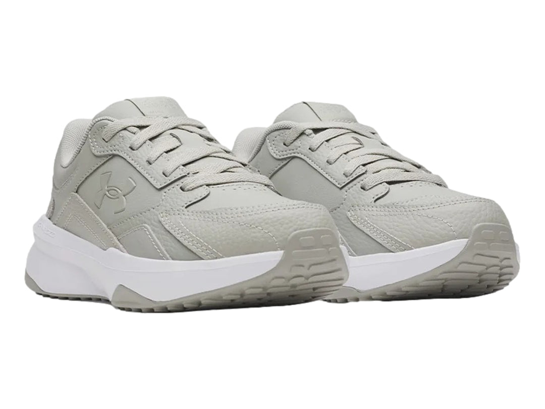 Tenis deportivos Under Armour en color gris con suela blanca.