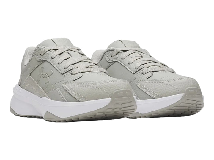 Tenis deportivos Under Armour en color gris con suela blanca.