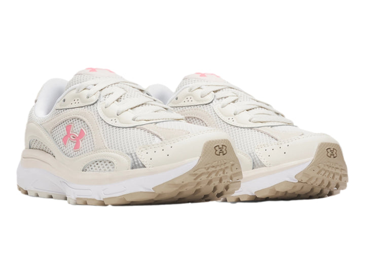 Tenis deportivos Under Armour de color blanco con detalles en rosa y suela blanca.