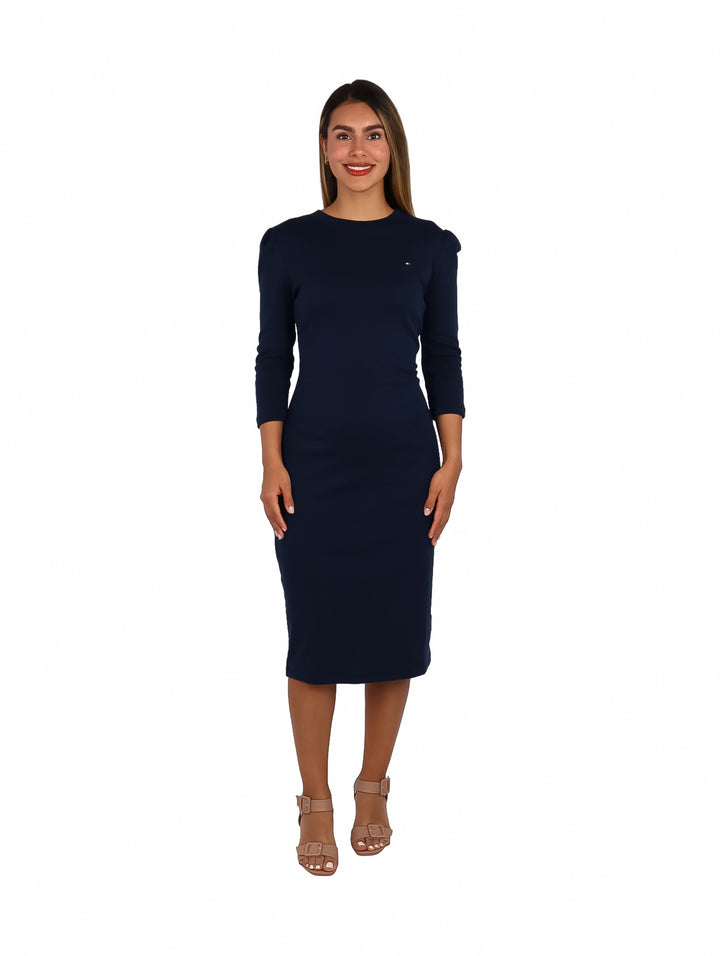 Mujer vistiendo un vestido midi ajustado color azul marino oscuro de la marca Tommy Hilfiger.