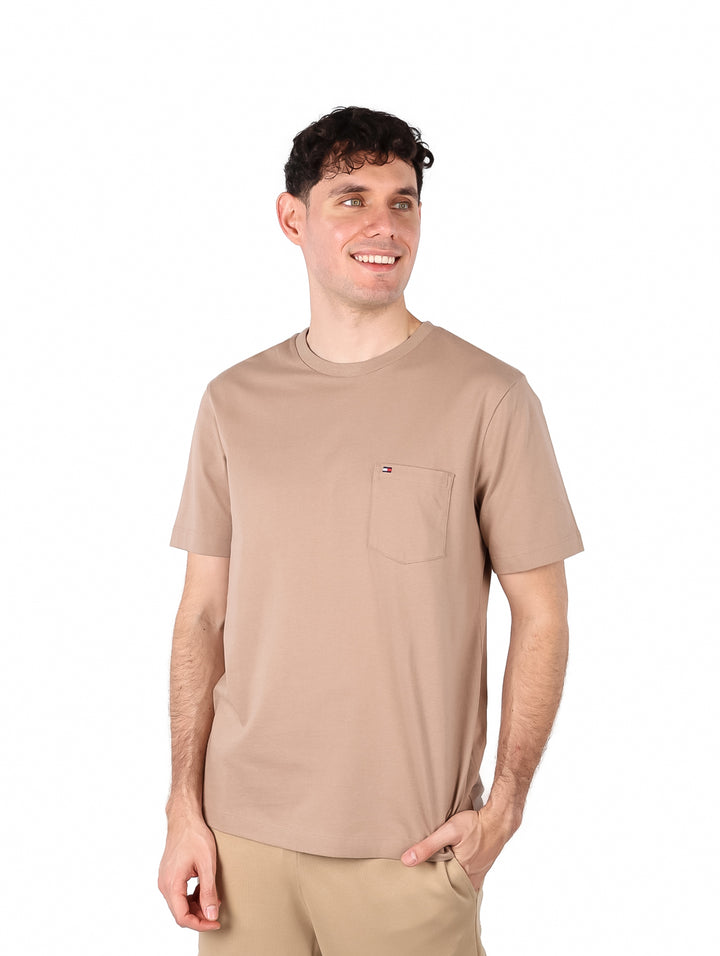 Hombre vistiendo una camiseta de manga corta color taupe con un pequeño bolsillo en el pecho.
