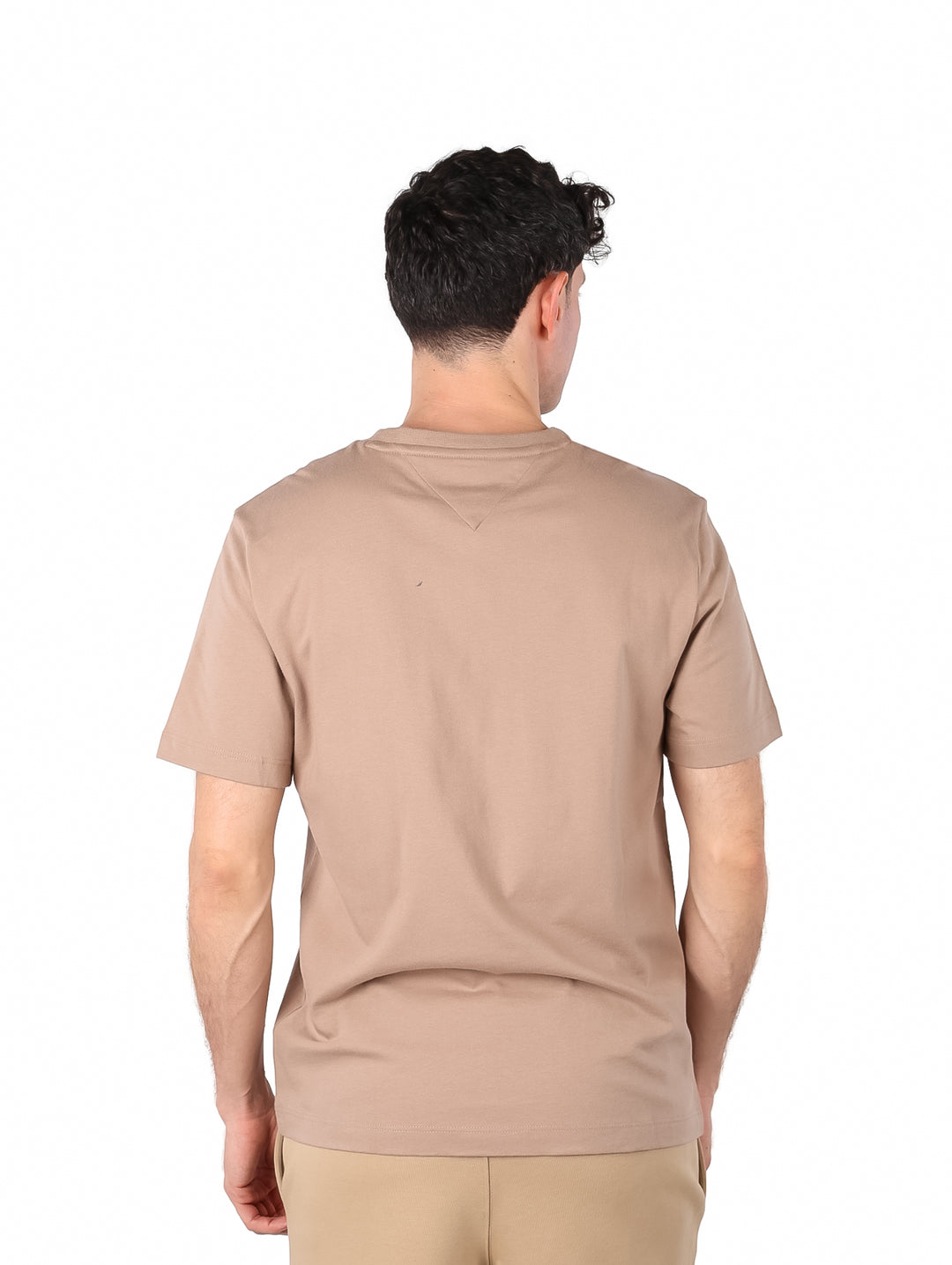 Hombre vistiendo una camiseta de manga corta color taupe con un pequeño bolsillo en el pecho.