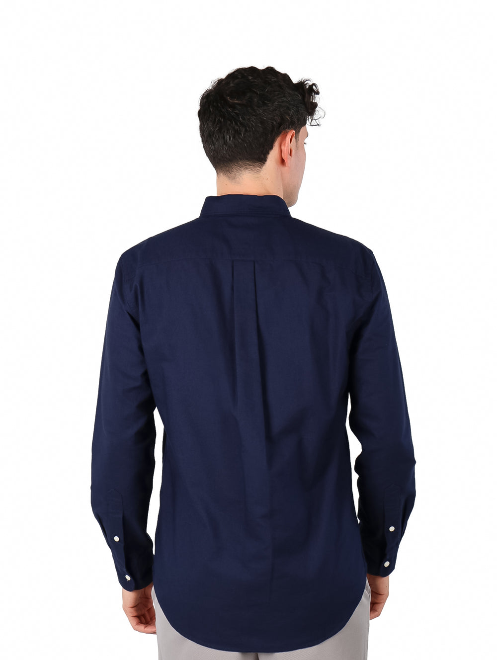 Hombre vistiendo una camisa Tommy Hilfiger de color azul marino con botones blancos y manga larga.