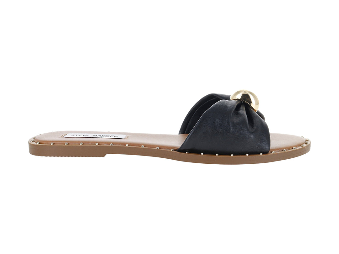 Sandalia plana Steve Madden color negro con detalle circular dorado en la parte superior y suela beige.