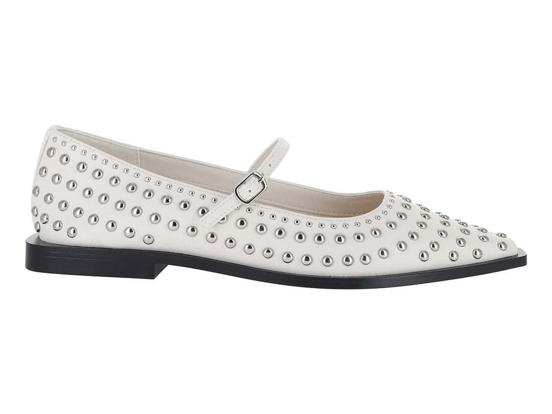 Zapatos planos color marfil con estoperoles metálicos y correa ajustable.
