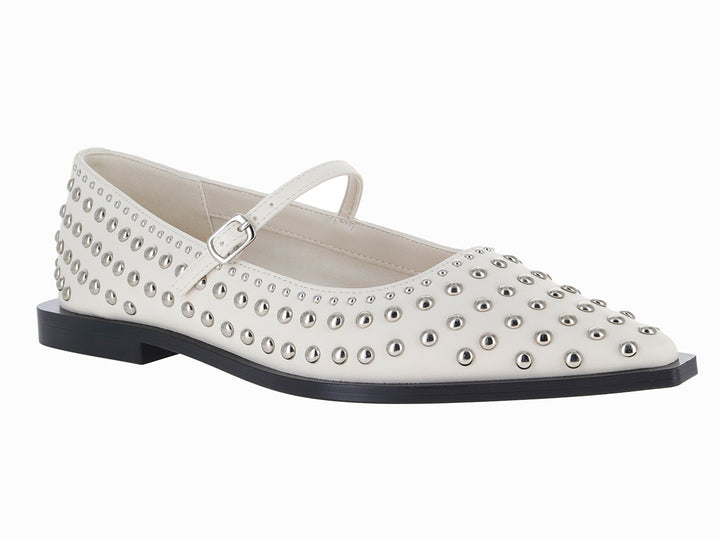 Zapatos planos color marfil con estoperoles metálicos y correa ajustable.
