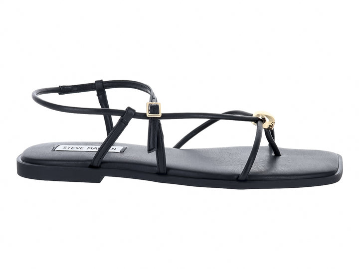 Sandalias planas negras con tiras y hebillas doradas de la marca Steve Madden.