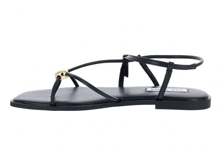 Sandalias planas negras con tiras y hebillas doradas de la marca Steve Madden.