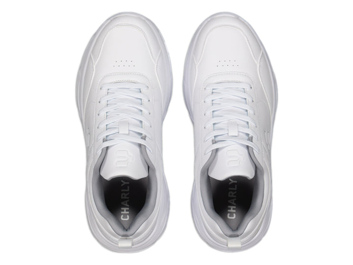 Tenis deportivos Charly color blanco con suela robusta y cordones, vista lateral sobre fondo blanco.