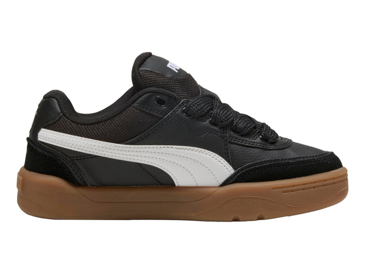 Tenis PUMA negros para niños con suela color café y franja blanca lateral.