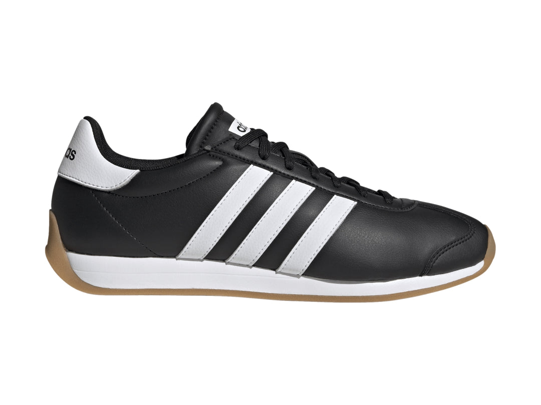Tenis Adidas Runvista color negro con tres franjas blancas y suela de goma marrón.