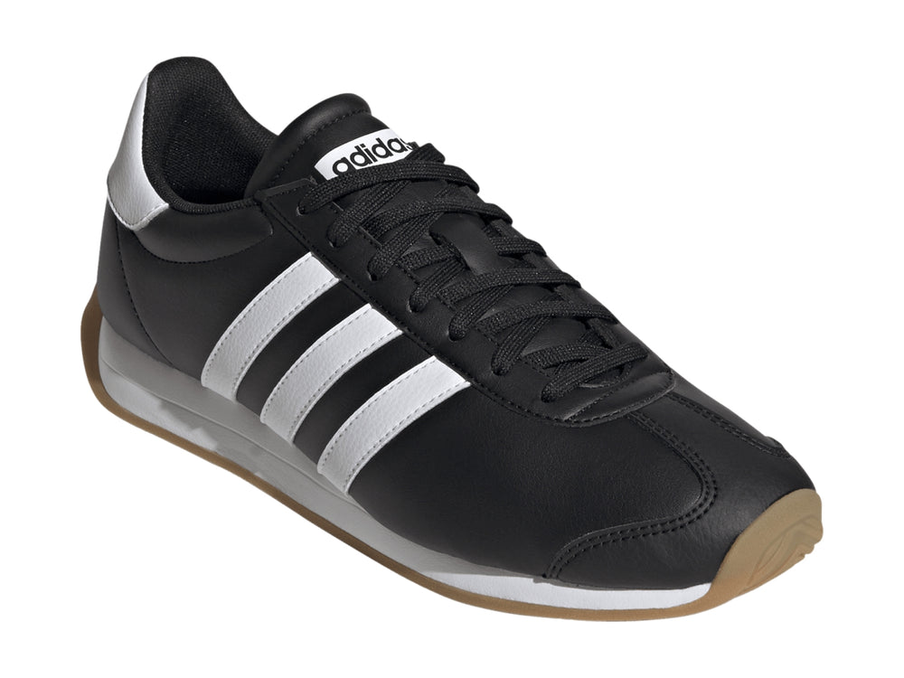 Tenis Adidas Runvista color negro con tres franjas blancas y suela de goma marrón.