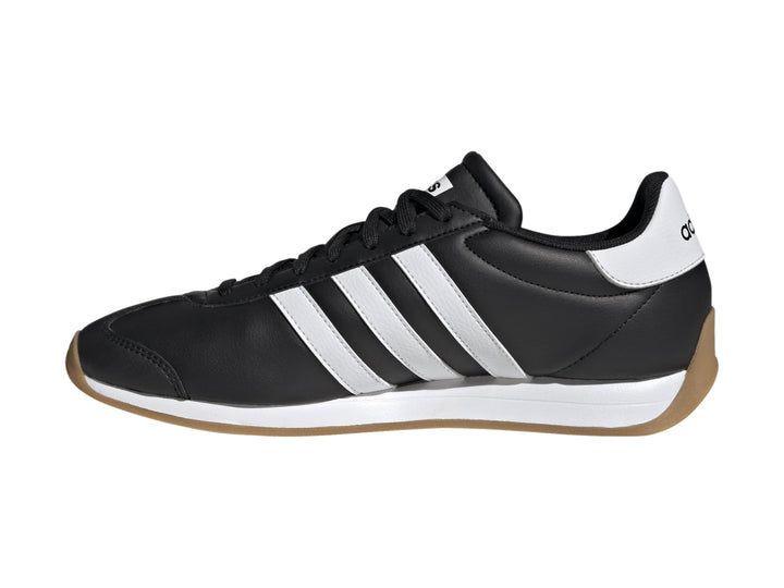Tenis Adidas Runvista color negro con tres franjas blancas y suela de goma marrón.