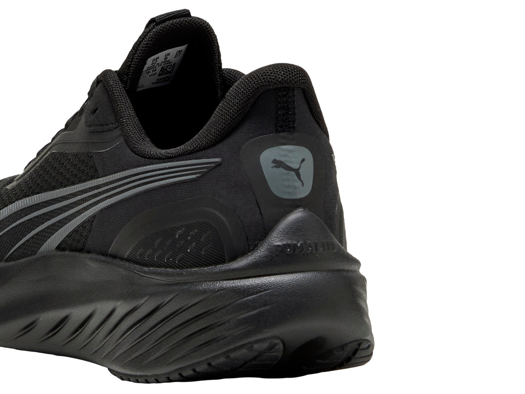 Tenis deportivos PUMA color negro con detalles en gris oscuro, vista lateral.