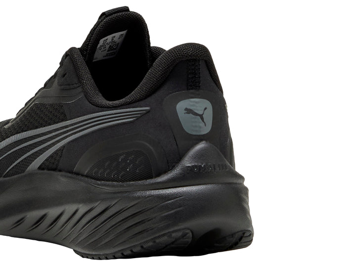 Tenis deportivos PUMA color negro con detalles en gris oscuro, vista lateral.