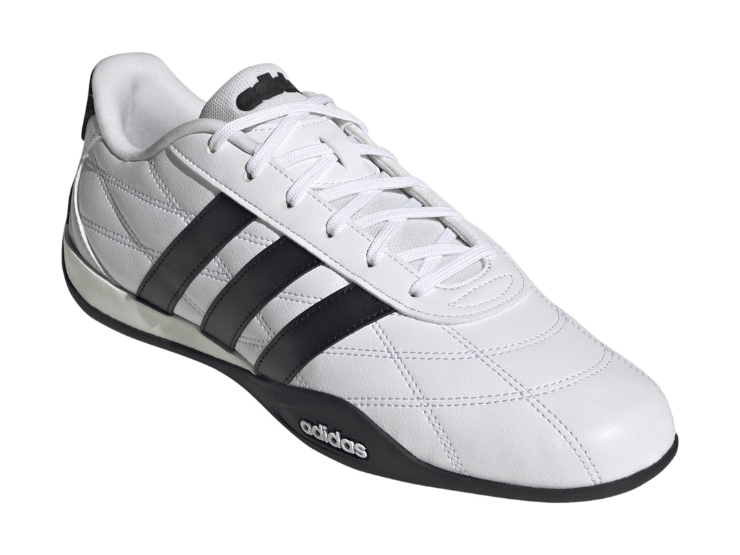 Tenis Adidas Adipista color blanco con tres franjas negras laterales y suela negra.