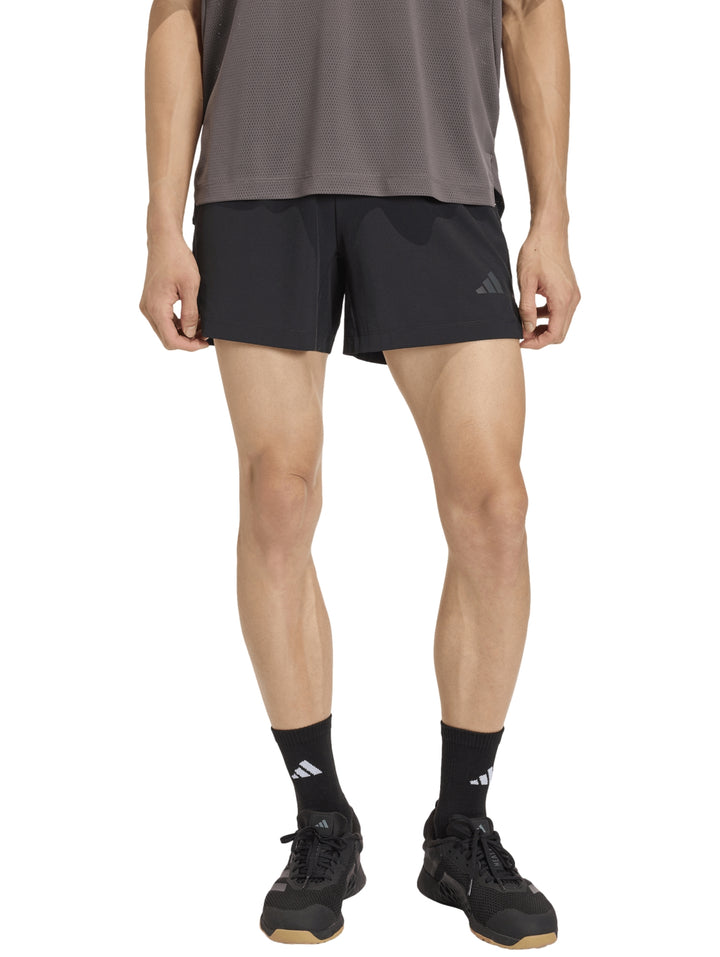 Hombre vistiendo shorts deportivos negros de la marca Adidas.