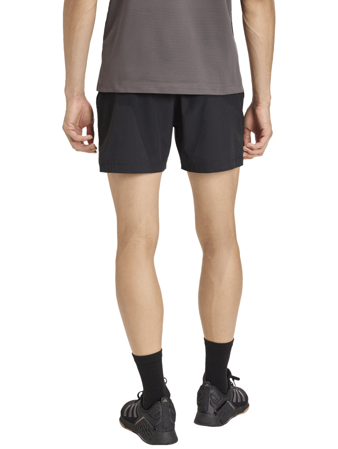 Hombre vistiendo shorts deportivos negros de la marca Adidas.