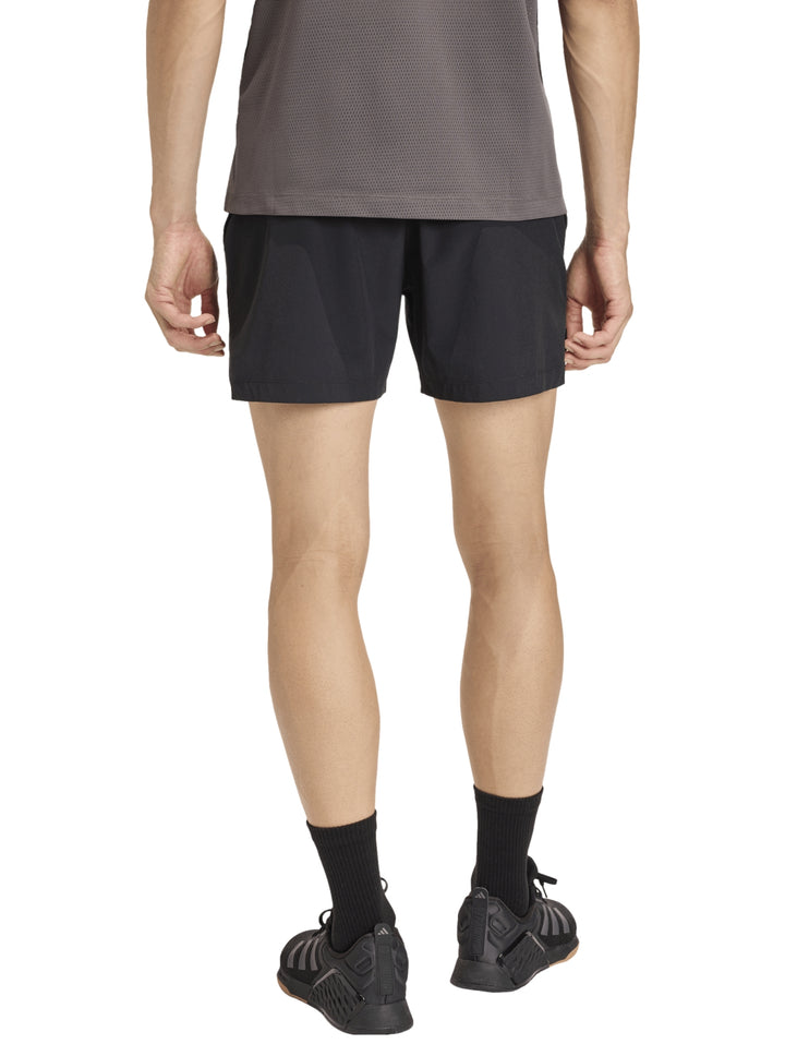 Hombre vistiendo shorts deportivos negros de la marca Adidas.