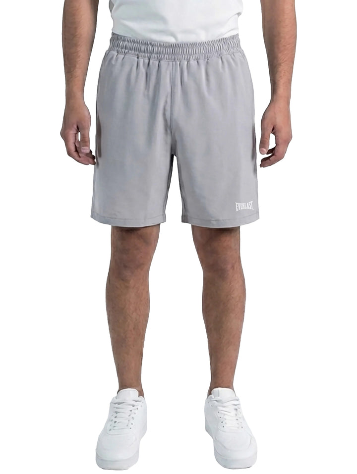 Hombre vistiendo shorts deportivos de color gris marca Everlast con cintura elástica.