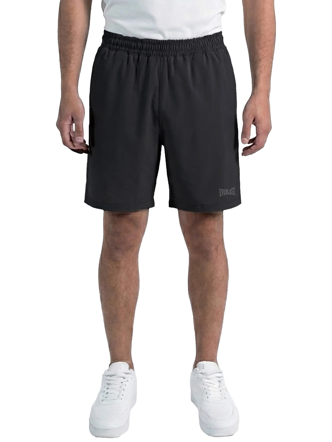 Hombre vistiendo shorts deportivos color negro de la marca Everlast con tenis blancos.