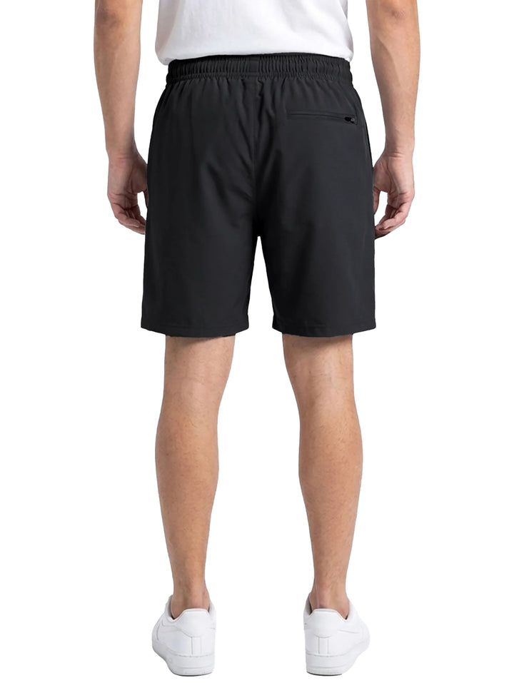 Hombre vistiendo shorts deportivos color negro de la marca Everlast con tenis blancos.