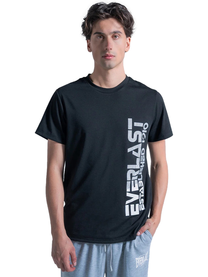 Hombre vistiendo playera deportiva negra de manga corta con logotipo blanco vertical de Everlast.