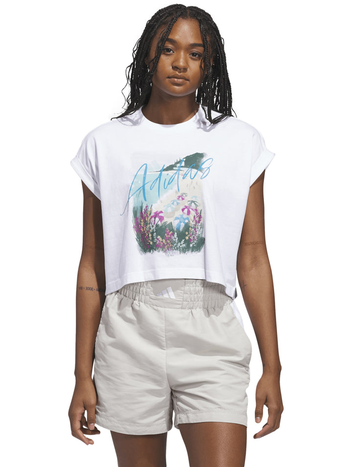 Camiseta blanca Adidas con estampado gráfico floral colorido en el frente.