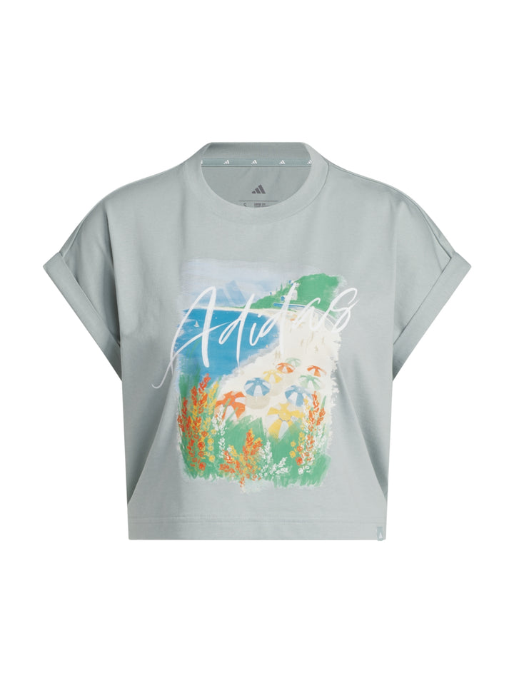 Playera Adidas color Wonder Sage con estampado gráfico frontal y cuello redondo.