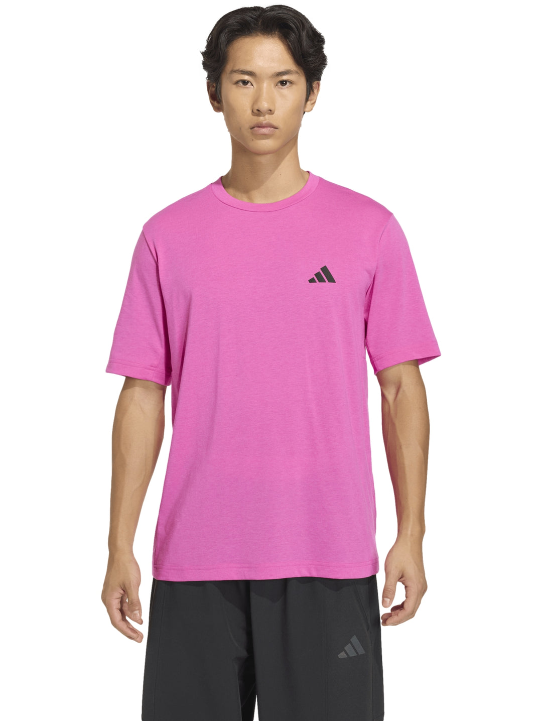 Hombre usando playera deportiva Adidas color fucsia con cuello redondo y manga corta.