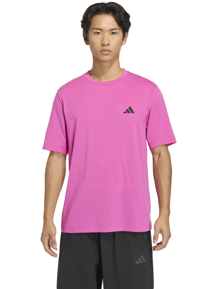 Hombre usando playera deportiva Adidas color fucsia con cuello redondo y manga corta.