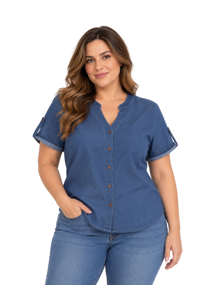Mujer vistiendo blusa azul de manga corta con botones frontales y pantalones vaqueros.