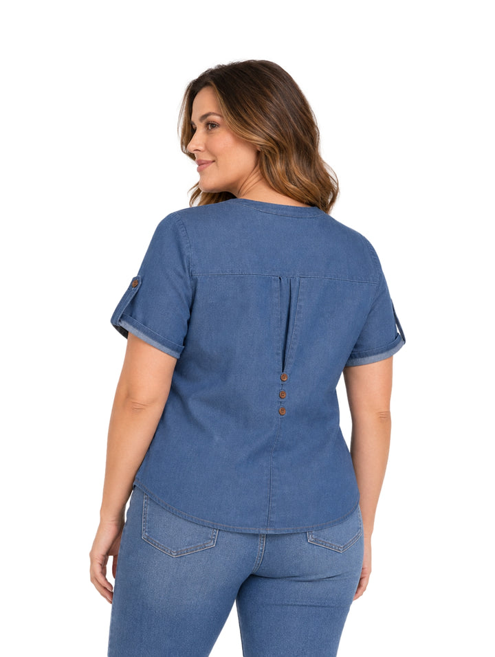 Mujer vistiendo blusa azul de manga corta con botones frontales y pantalones vaqueros.