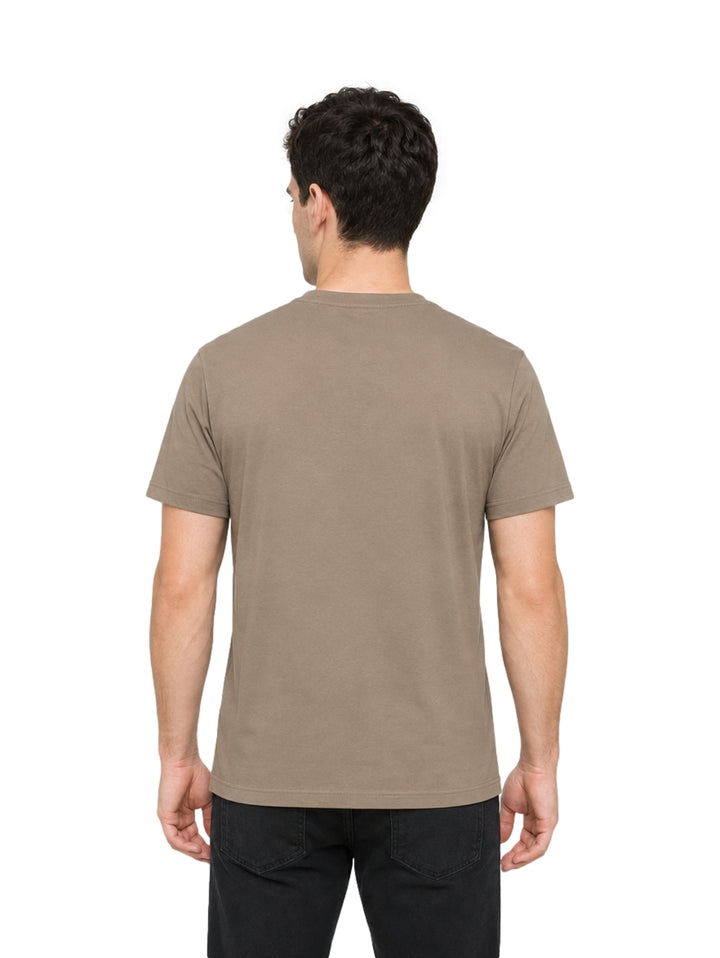 Hombre vistiendo playera Hurley color iguana con estampado gráfico frontal en tonos beige y blanco.