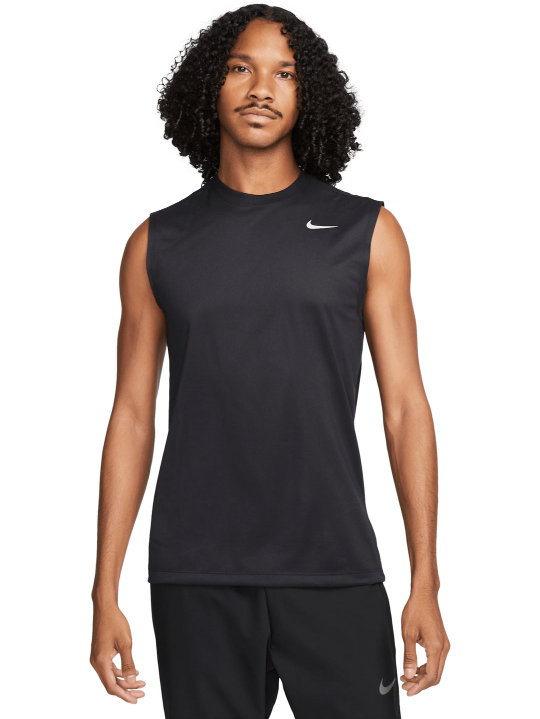Hombre vistiendo una camiseta deportiva sin mangas de color negro con logotipo de Nike en color plata.