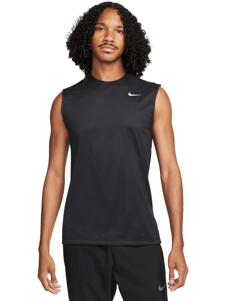 Hombre vistiendo una camiseta deportiva sin mangas de color negro con logotipo de Nike en color plata.