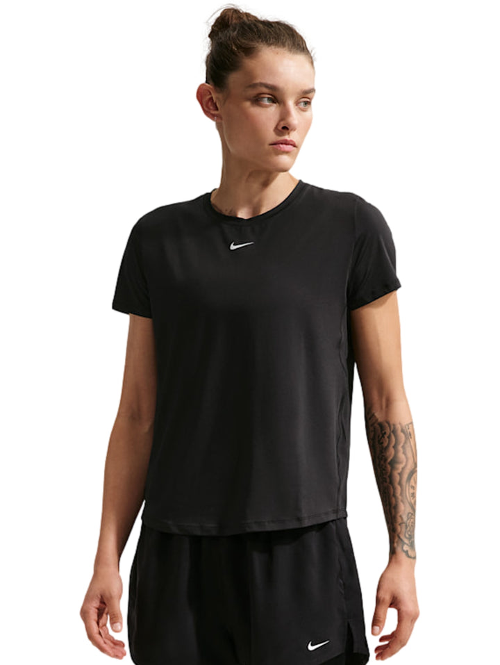 Mujer vistiendo una camiseta deportiva Nike de color negro con manga corta y logo blanco en el pecho.