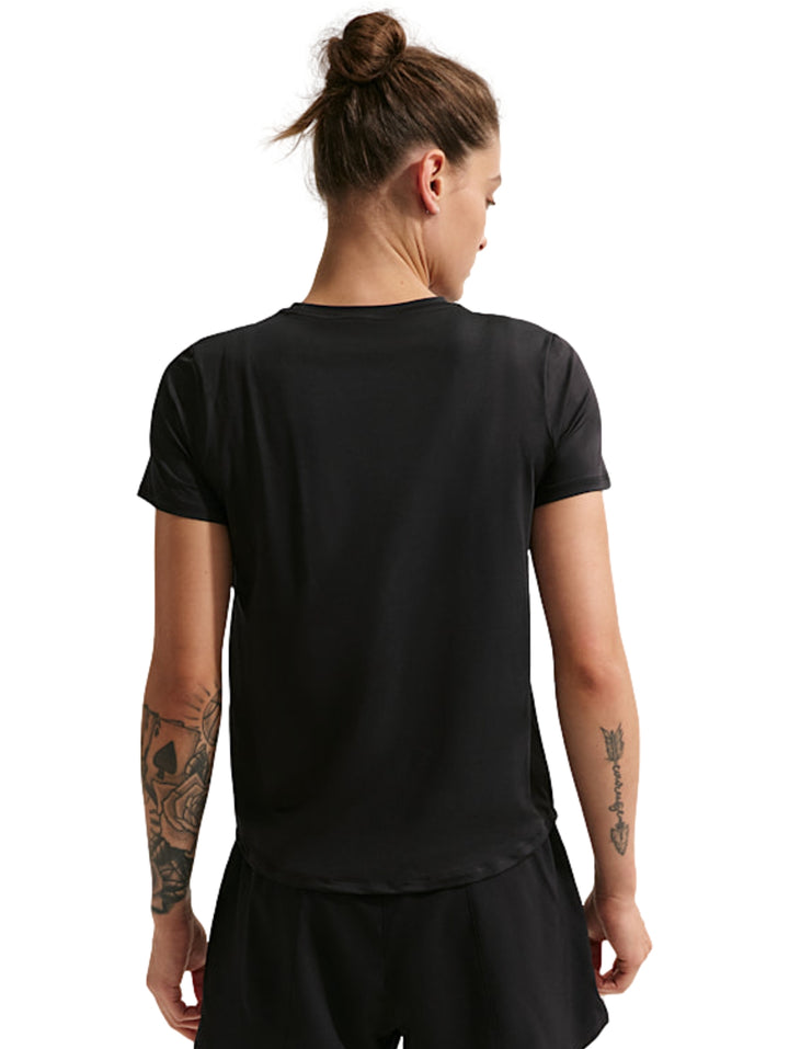 Mujer vistiendo una camiseta deportiva Nike de color negro con manga corta y logo blanco en el pecho.
