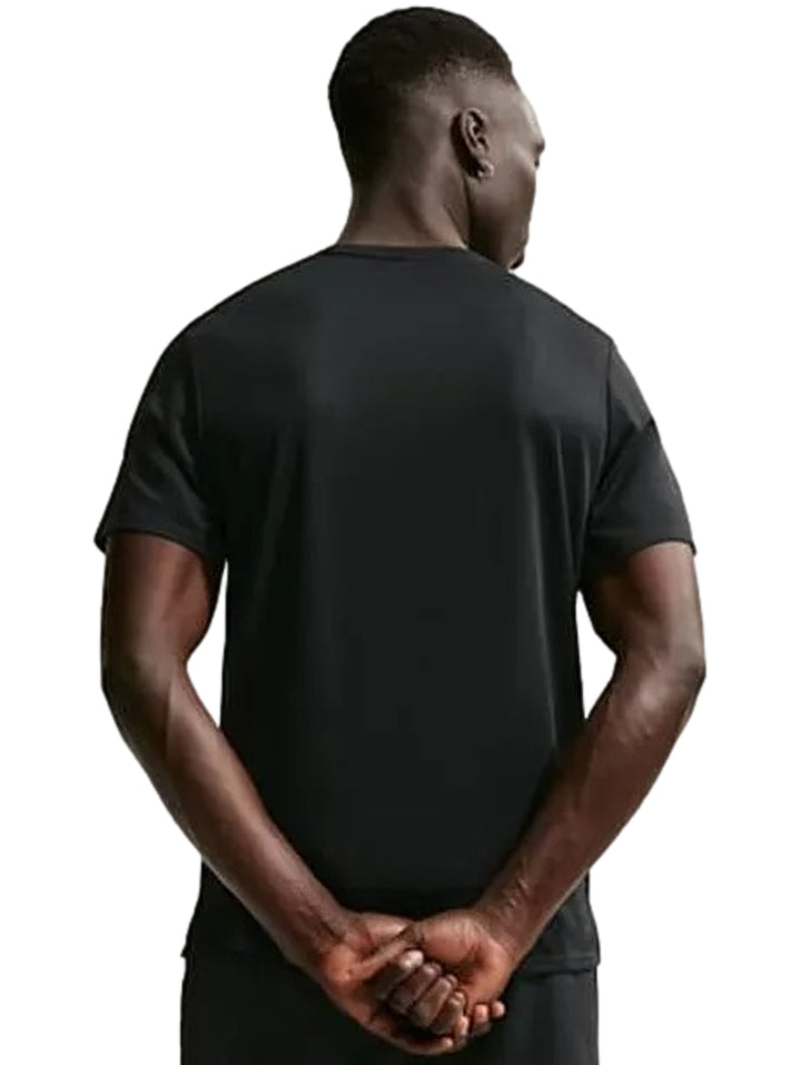 Hombre vistiendo camiseta deportiva Nike de color negro con logotipo blanco &
