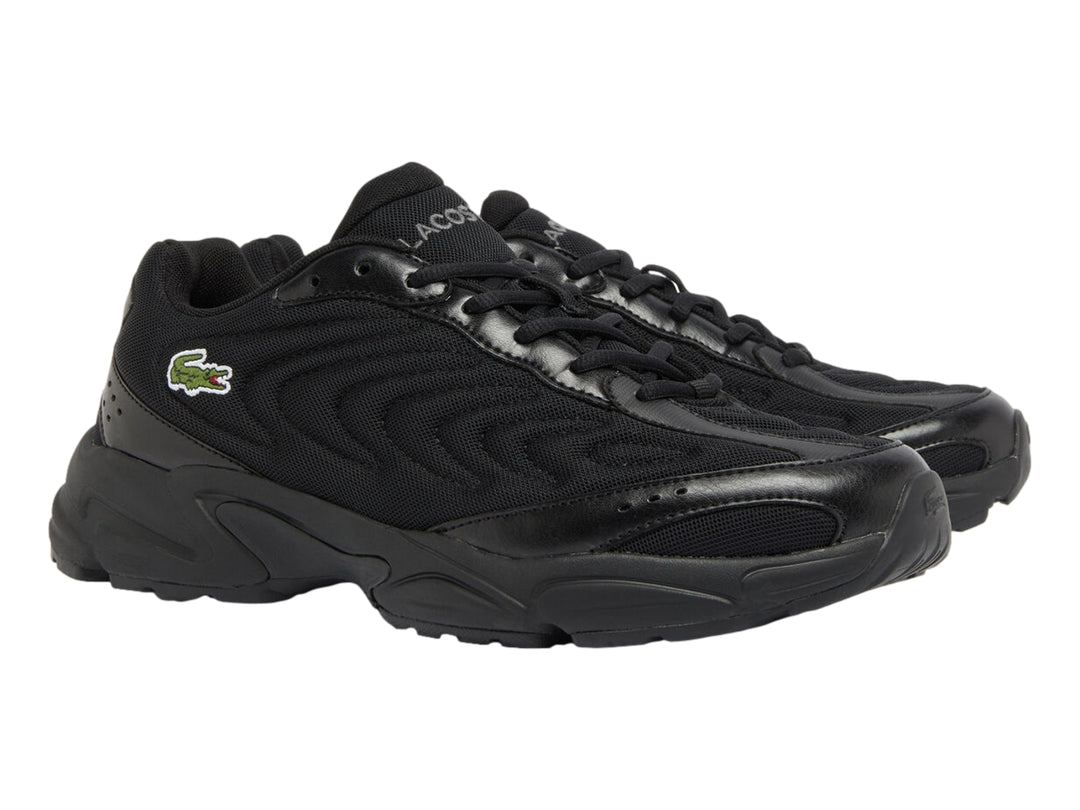 Tenis deportivos Lacoste en color negro con suela gruesa y detalles en malla.