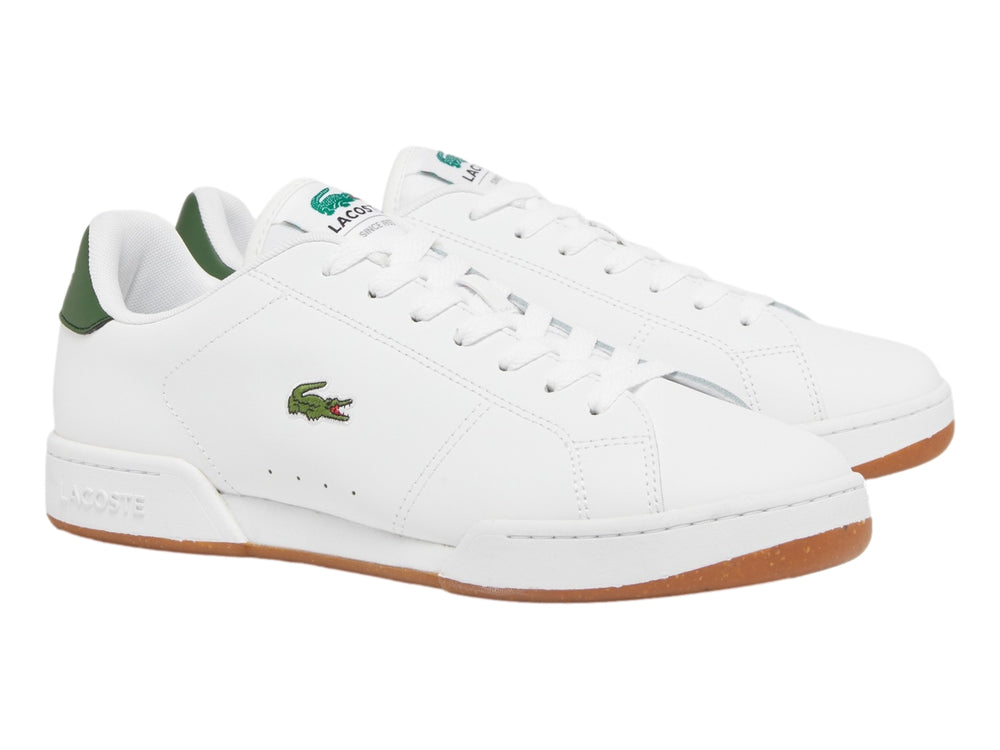 Tenis blancos Lacoste con detalle verde en el talón y suela color café.