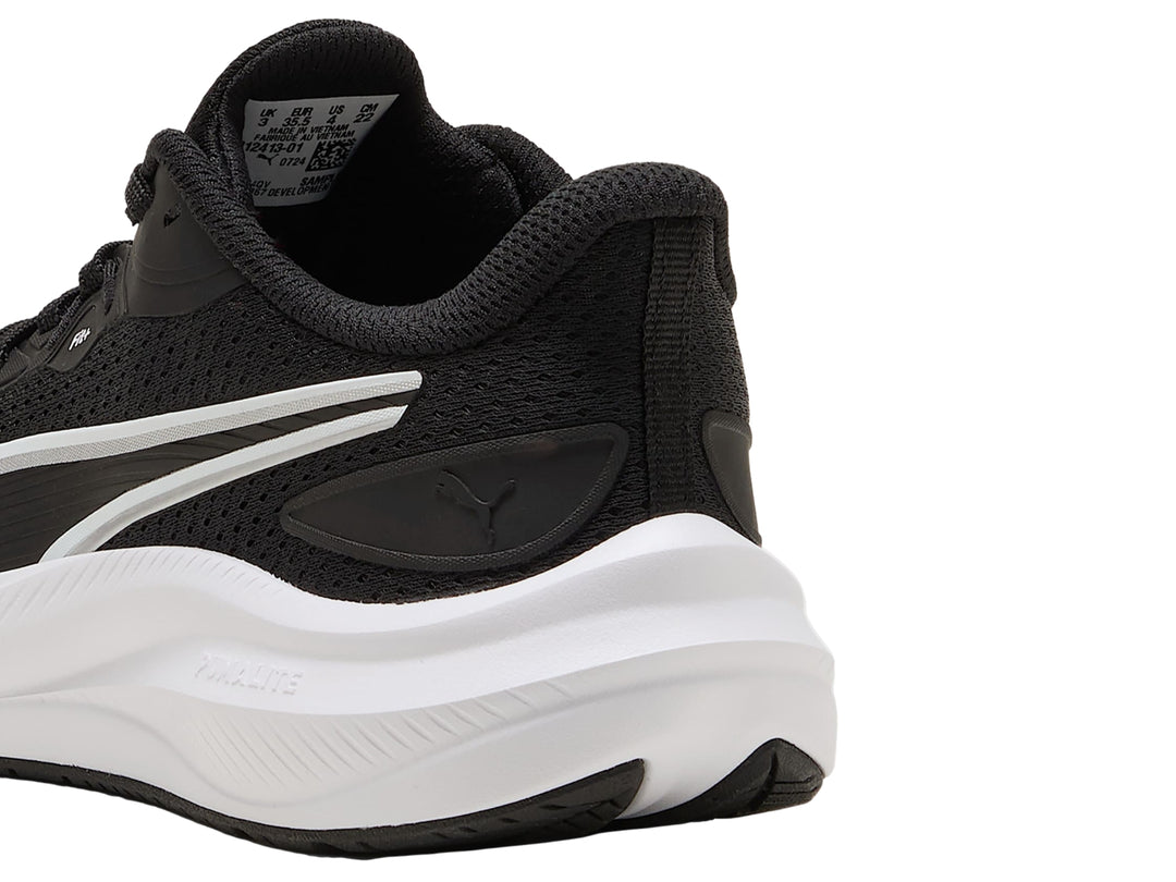 Tenis deportivos PUMA para niños en color negro con suela blanca y detalles laterales blancos.