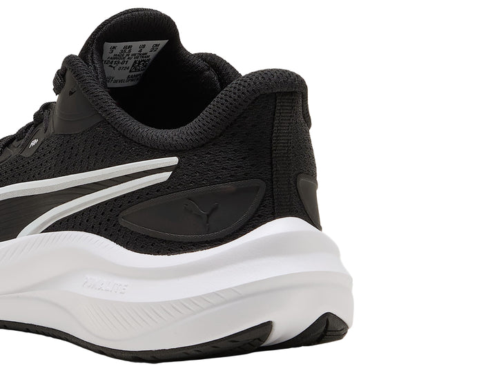 Tenis deportivos PUMA para niños en color negro con suela blanca y detalles laterales blancos.
